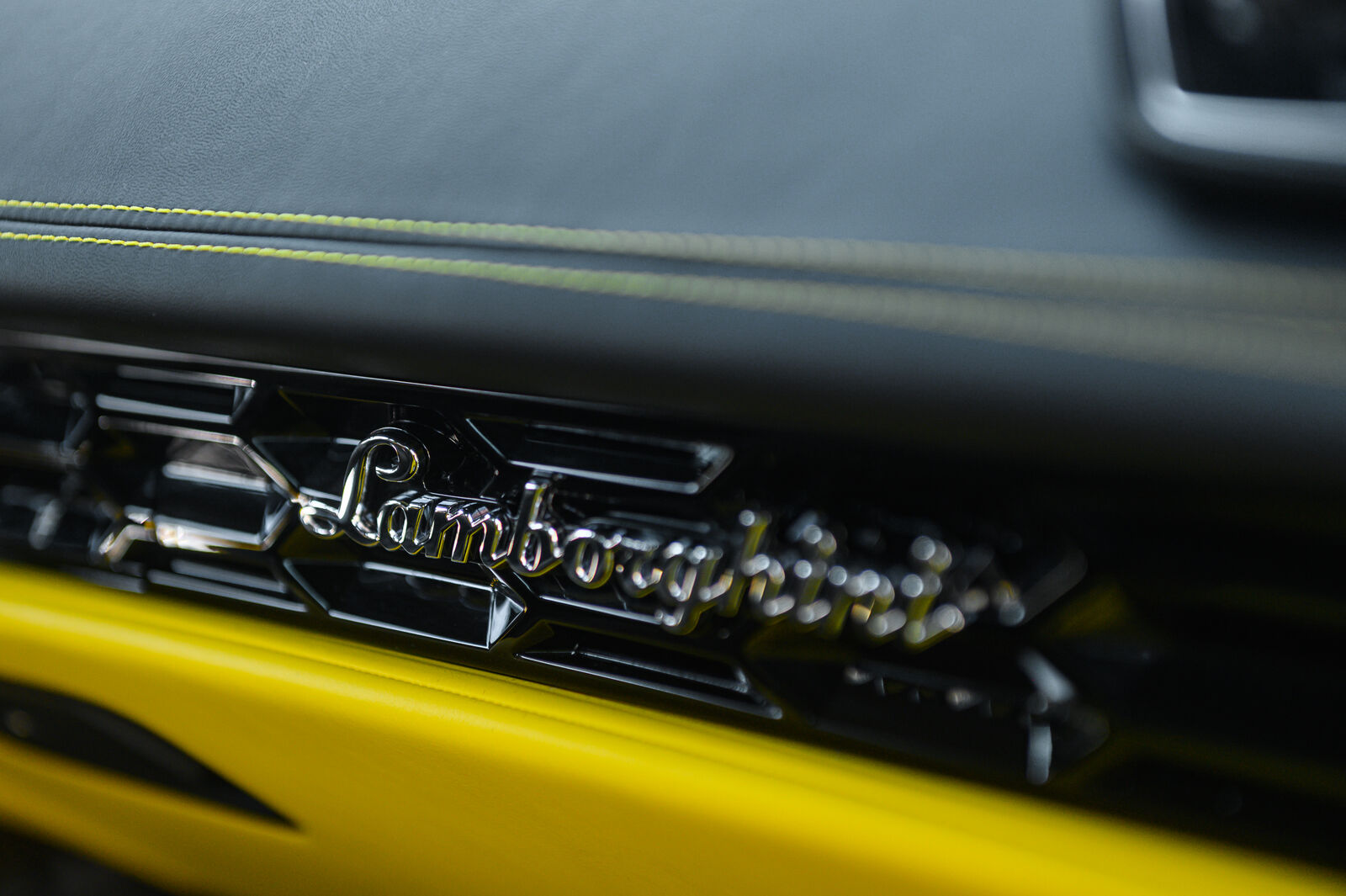 Lamborghini script on dashboard with yellow contrast stitching